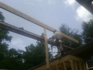 Carpenter setting a ridge beam over a new addition frame — Ice Dam Removal by Roofing Brothers in Sugar City