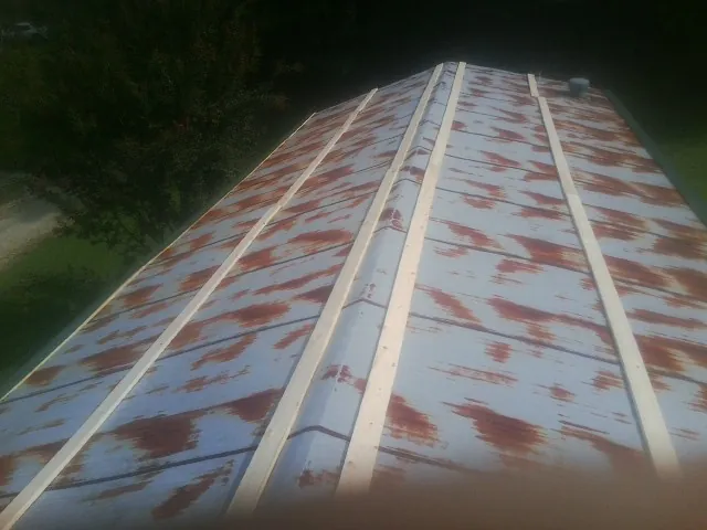 Rusted metal roof panels with new wood purlins before replacement — Storm Damage Roof Repair in Sugar City by Roofing Brothers
